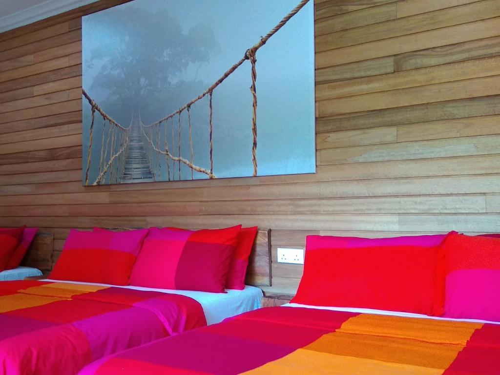 two beds in a room with a bridge on the wall at Naura Roomstay in Kuala Tahan