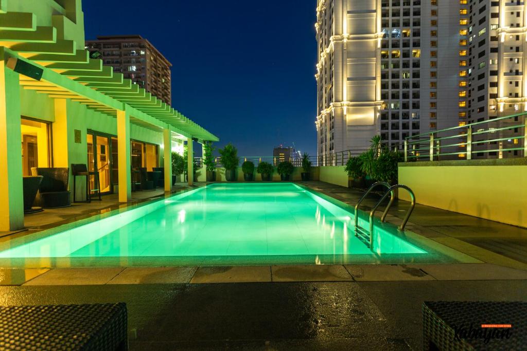 a swimming pool in the middle of a city at night at Armada Hotel Manila in Manila