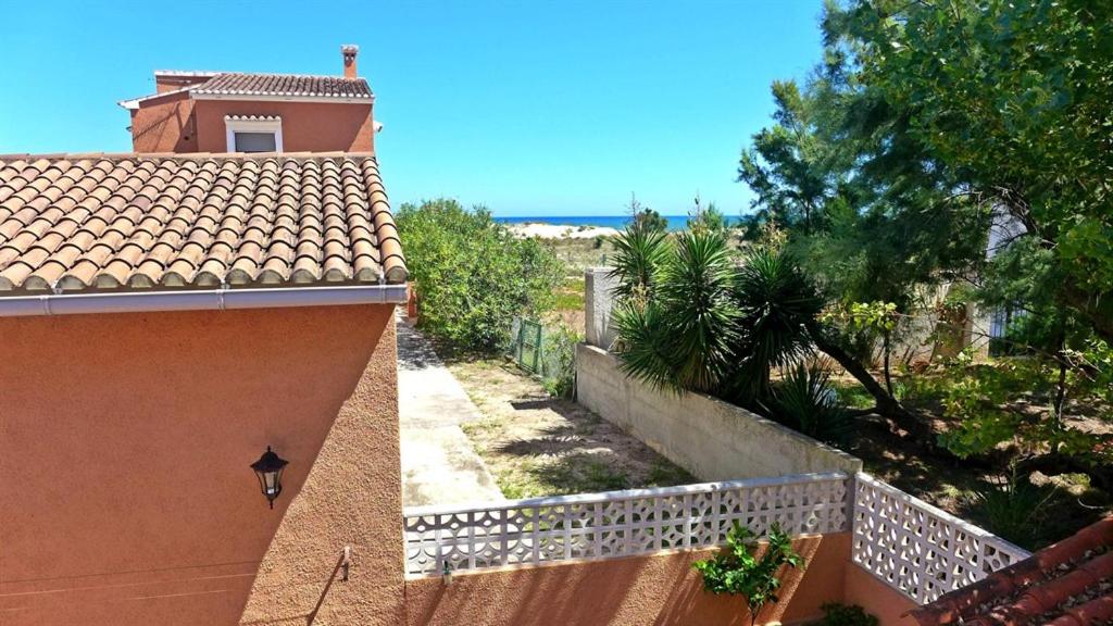 un edificio naranja con una valla y vistas al océano en Anacasa Bassetes Playa San Fernando CA550, en Oliva