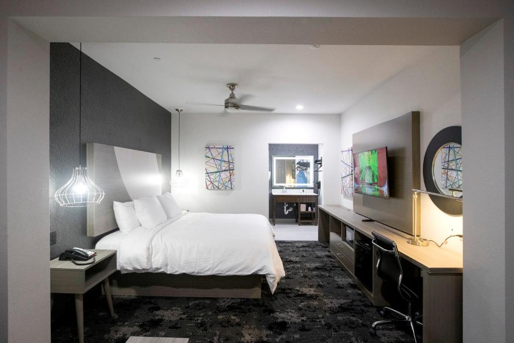 a bedroom with a bed and a desk and a tv at House Hotel in Houston