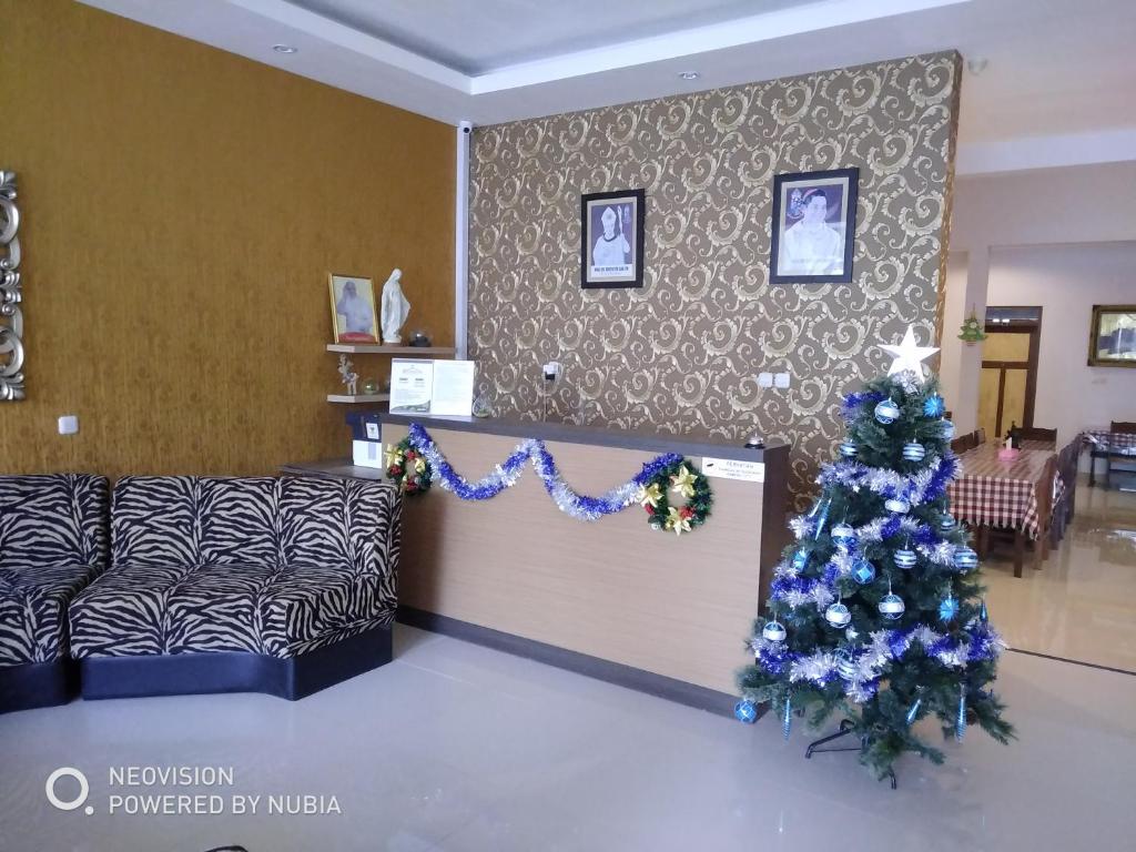 a christmas tree in a living room with a couch at Rumah Retret Bethania in Kuta