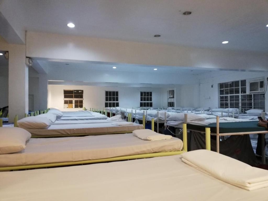 Una habitación con un montón de camas. en Dormitels.ph Ermita en Manila
