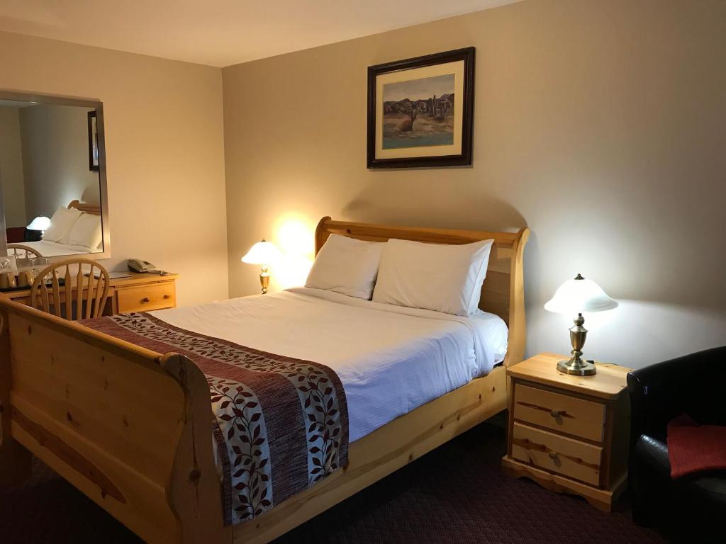 a bedroom with a large bed and a mirror at Cactus Tree Inn in Oliver
