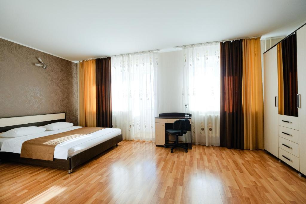 トムスクにあるApart Petrovskie at Bazarnykh 12のベッドルーム1室(ベッド1台、デスク付)