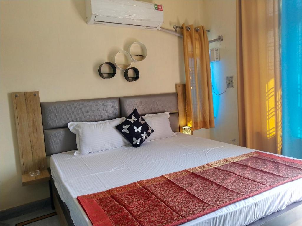 a bedroom with a bed with white sheets and pillows at Om Shanthi paying guest house in Varanasi