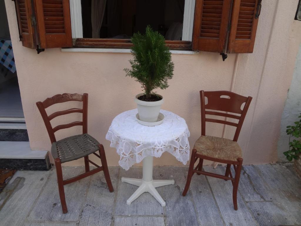 stół z dwoma krzesłami i doniczką w obiekcie Korthi central appartment by the seaside. w mieście Órmos
