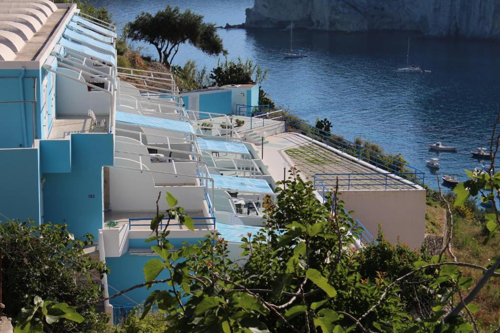 una fila de edificios azules y blancos junto al agua en Magi - Appartamenti Maga Circe, en Ponza