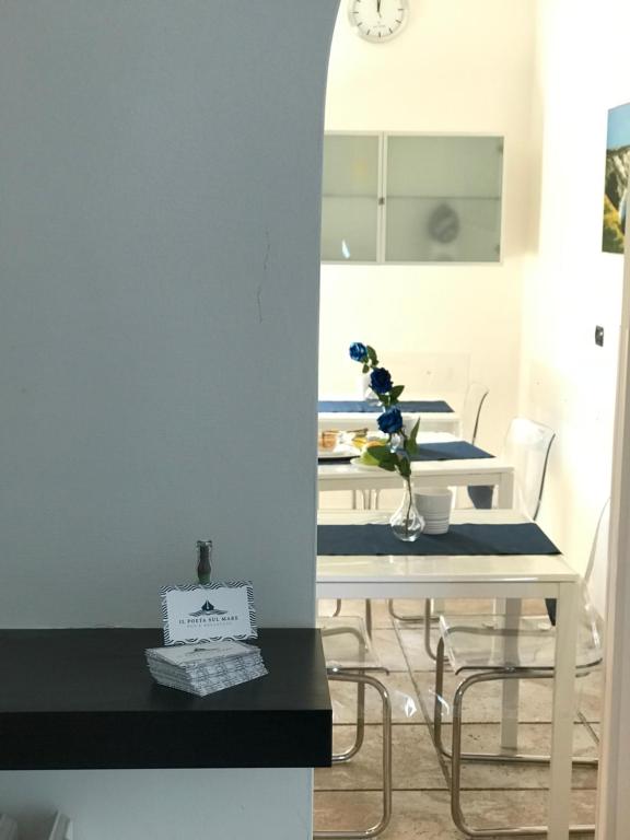 una sala da pranzo con tavolo e sedie bianchi di B&B Il Poeta sul Mare ad Ancona