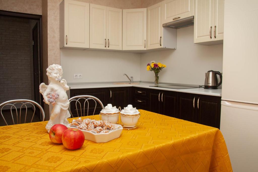 クラスノダールにあるАпартаменты на Старокубанскойのキッチン(食べ物とりんごを入れたテーブル付)