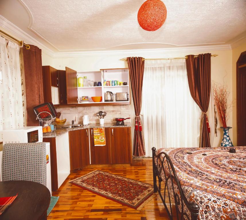 Sherry Homes - Kwetu في نيروبي: مطبخ مع سرير وطاولة في الغرفة