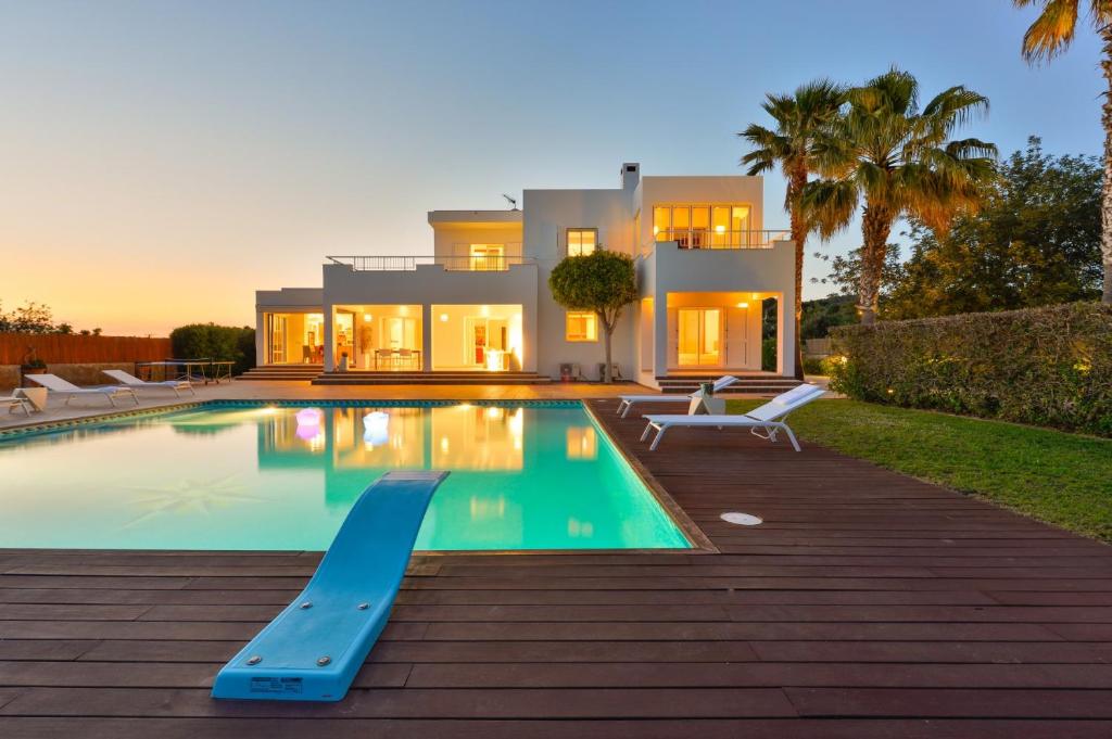 a villa with a swimming pool in front of a house at Villa Can Fluxa in Ibiza Town