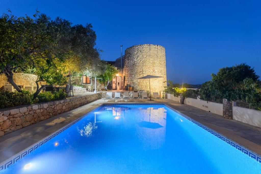 uma piscina em frente a um castelo à noite em Villa Torre Bes em San Antonio