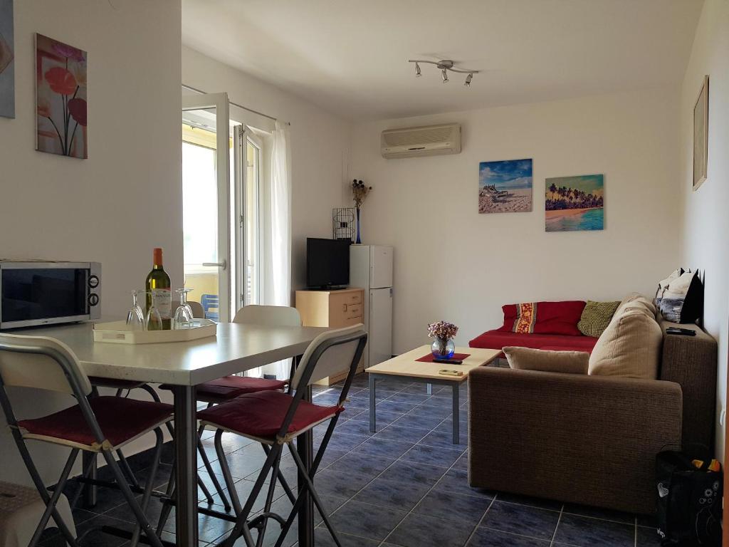 ein Wohnzimmer mit Tisch und Couch in der Unterkunft Apartment Blue Sky in Novalja