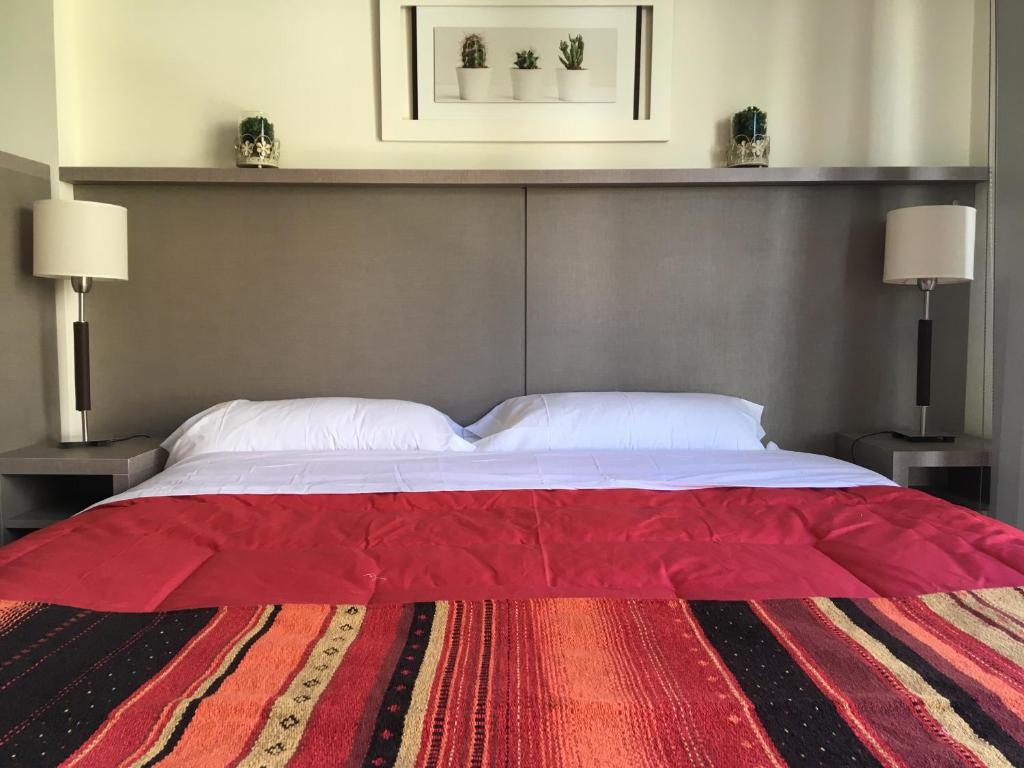 1 dormitorio con 1 cama grande de color rojo y 2 lámparas en Baritur en San Carlos de Bariloche