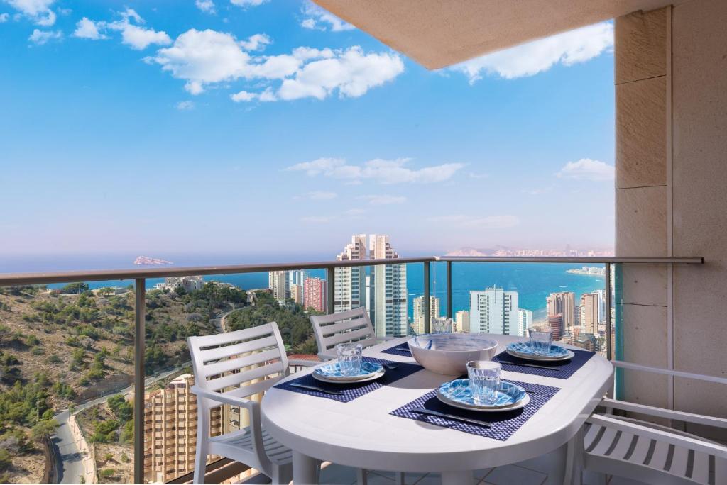 d'une table et de chaises sur un balcon avec vue sur la ville. dans l'établissement Apartamento Benidorm de Luxe, à Benidorm