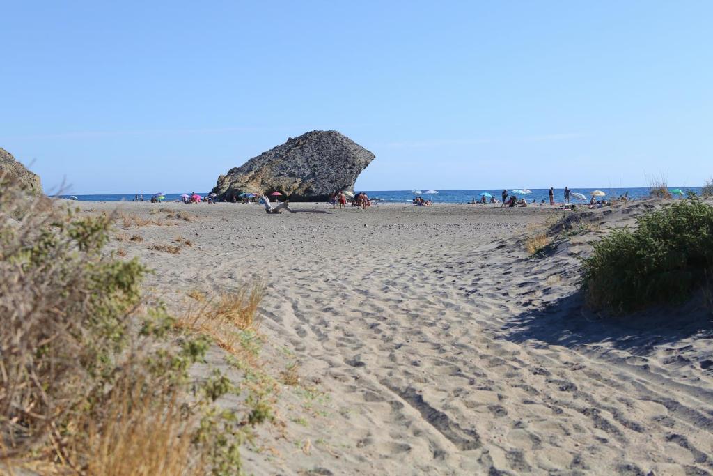 a sandy beach with a group of people on it at Apartahotel Vistamar San José in San José