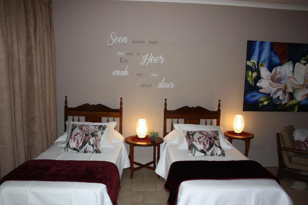 duas camas num quarto com duas lâmpadas na parede em Little Umhlanga em Pretoria