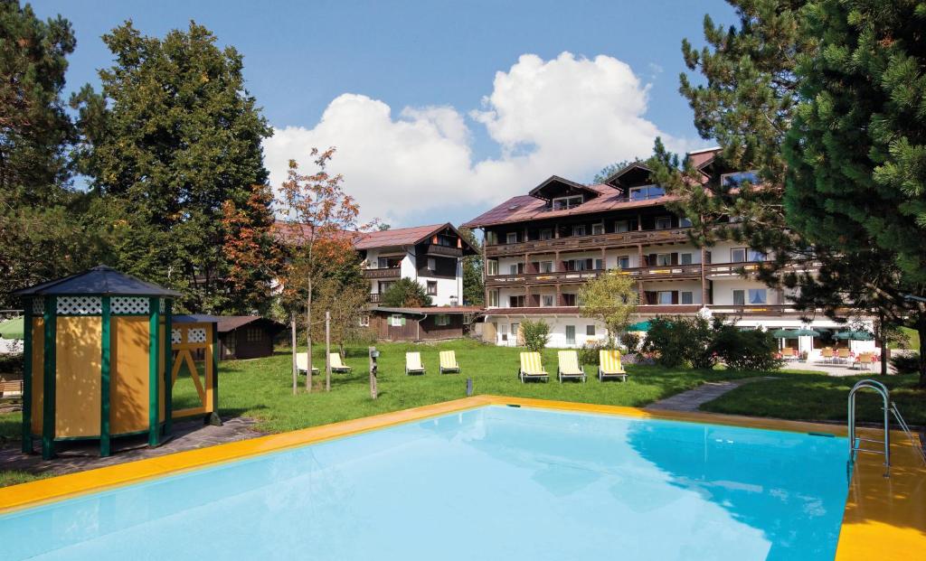 a large swimming pool in front of a hotel at Hotel garni Kappeler-Haus in Oberstdorf