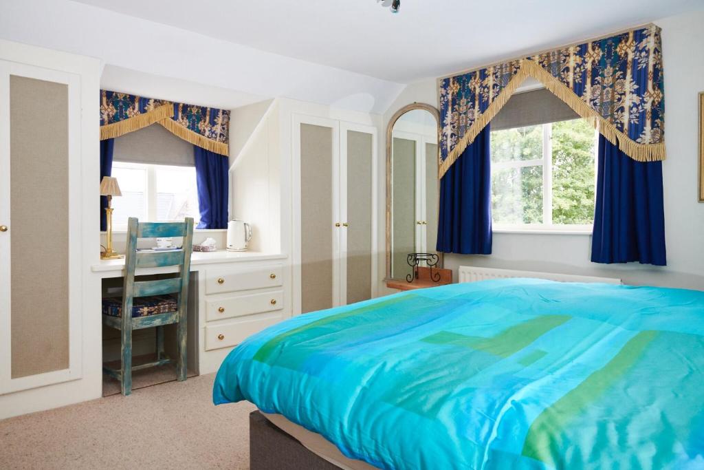 a bedroom with a blue bed and a desk at Tallow House in Ludlow