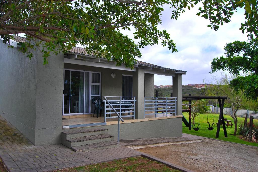 a small house with a porch and a deck at Aloe Ridge in Mossel Bay