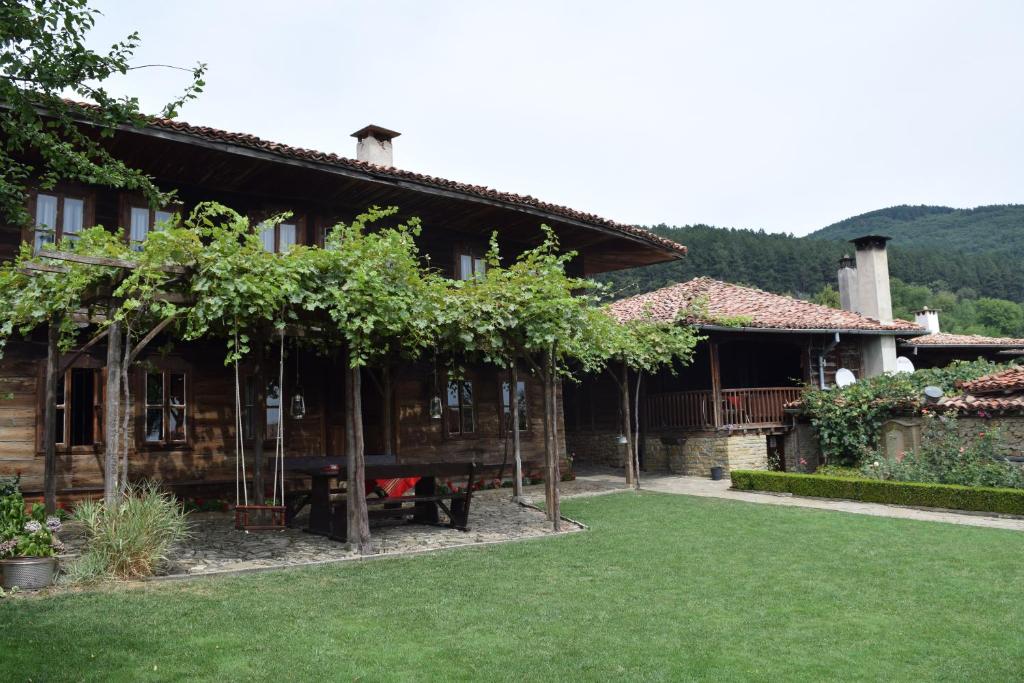 a house with a picnic table in front of it at Hadjigergy's Guest House in Zheravna