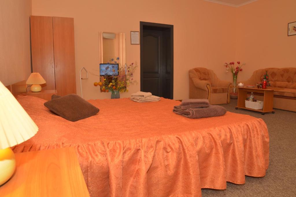 sypialnia z pomarańczowym łóżkiem i ręcznikami w obiekcie Отель "Экспресс" w mieście Żytomierz