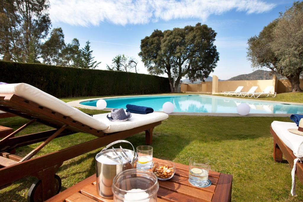patio trasero con piscina y mesa con mesa en Villa Gaudi en San Justo Desvern