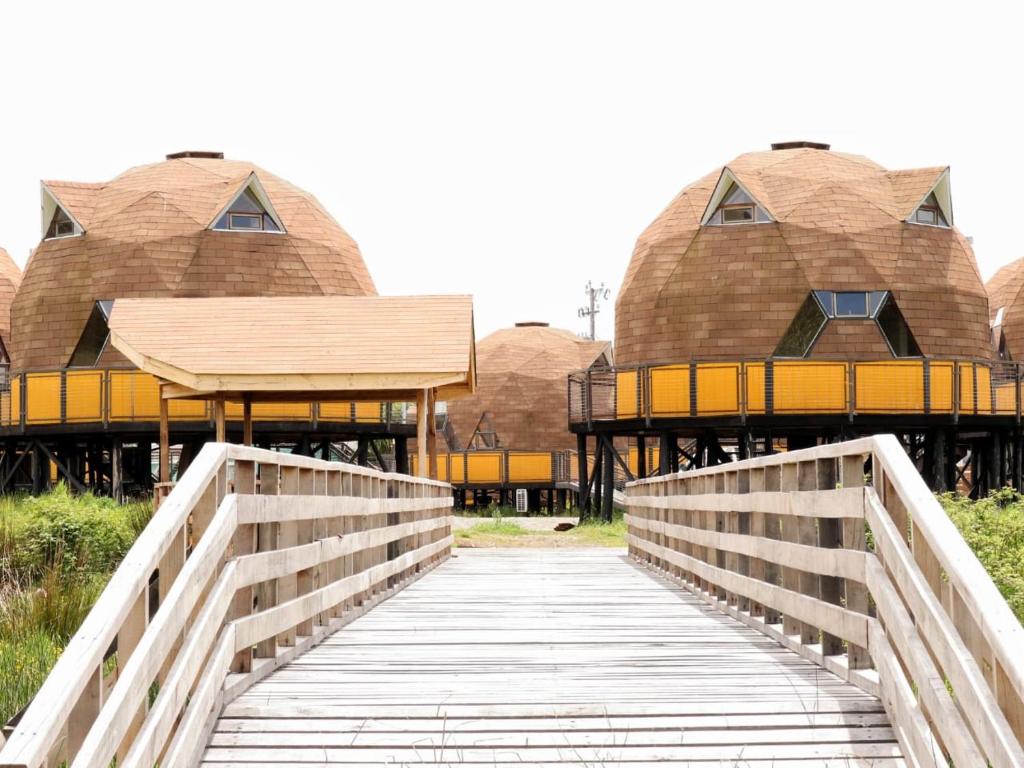 a bridge leading to a building with domes at Chiloe Domos Curaco de Vélez in Curaco de Velez