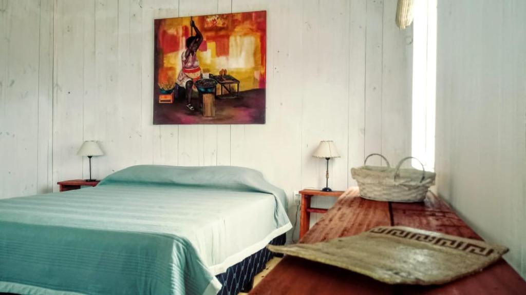 una camera da letto con un letto e un quadro sul muro di Arachania al Mar a Costa Azul