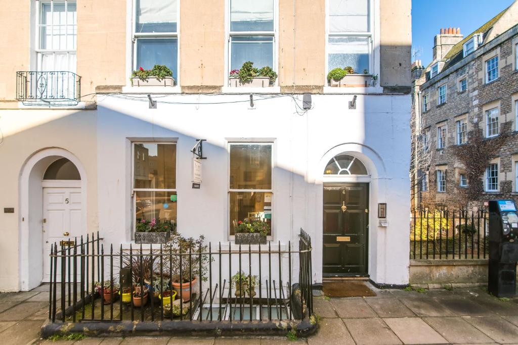 a white building with potted plants on the facade at The Henry Guest House in Bath