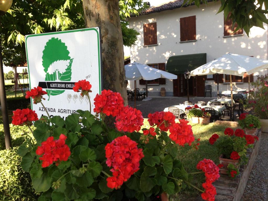 a sign with red flowers in front of a building at Agriturismo La Cavaliera in Monteveglio