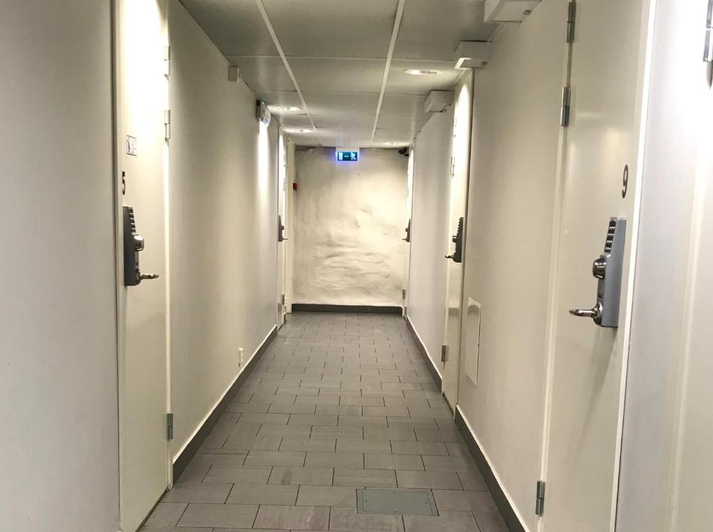 an empty corridor of an office building with a white hallway at Hostel Dalagatan in Stockholm