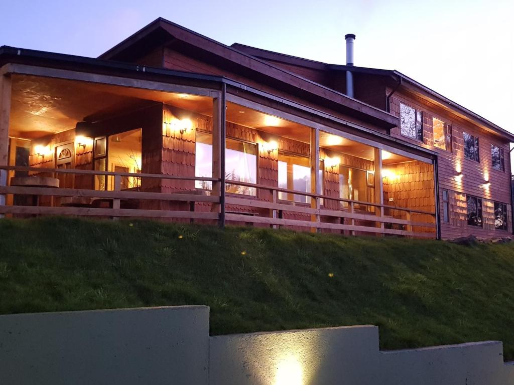 a house with lights on the front of it at Hotel y Cabañas Terrazas Vista al Mar hct in Ancud