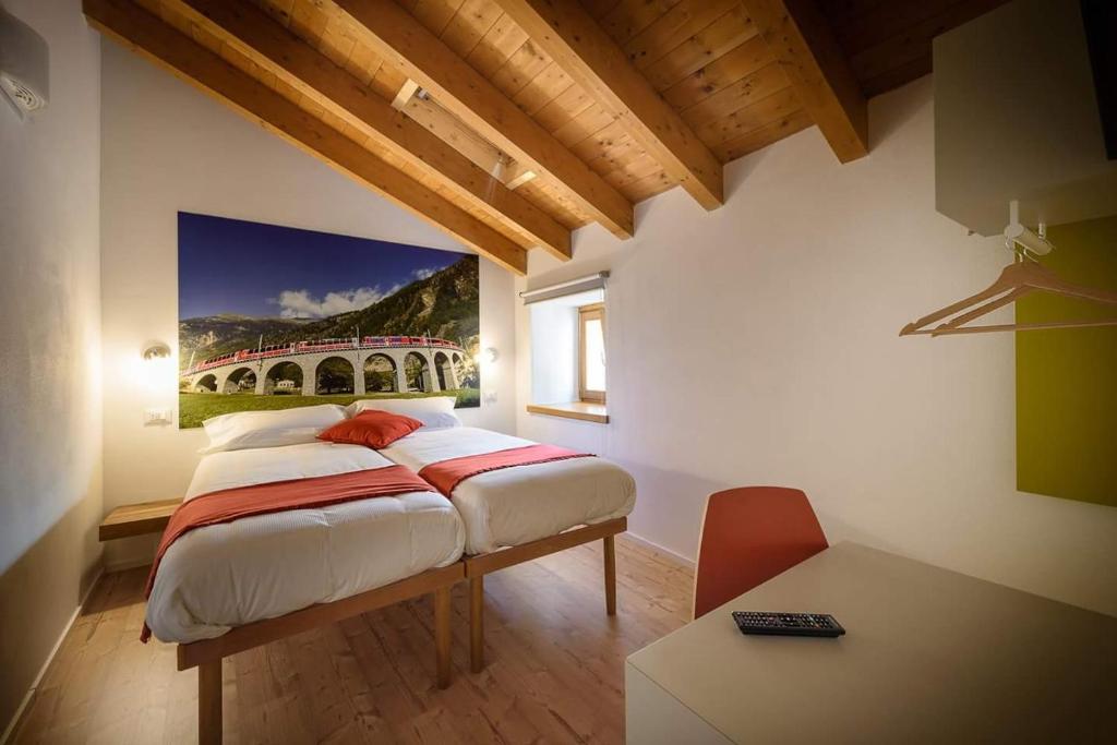 ティラーノにあるLe stanze del Trenino Rossoのベッドルーム1室(壁に絵画が描かれたベッド1台付)