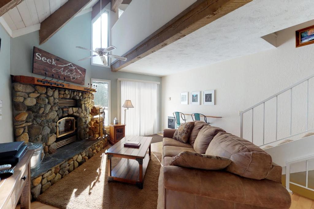 ein Wohnzimmer mit einem Sofa und einem Steinkamin in der Unterkunft Mammoth View Villas 21 in Mammoth Lakes