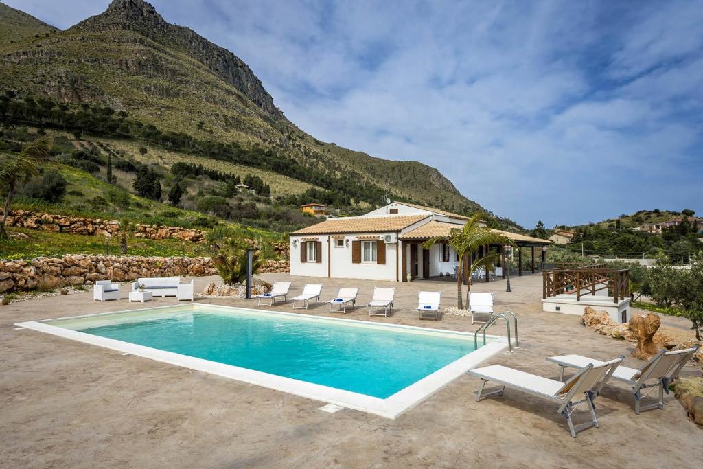 une villa avec une piscine en face d'une montagne dans l'établissement Villa Gea, à Castellammare del Golfo