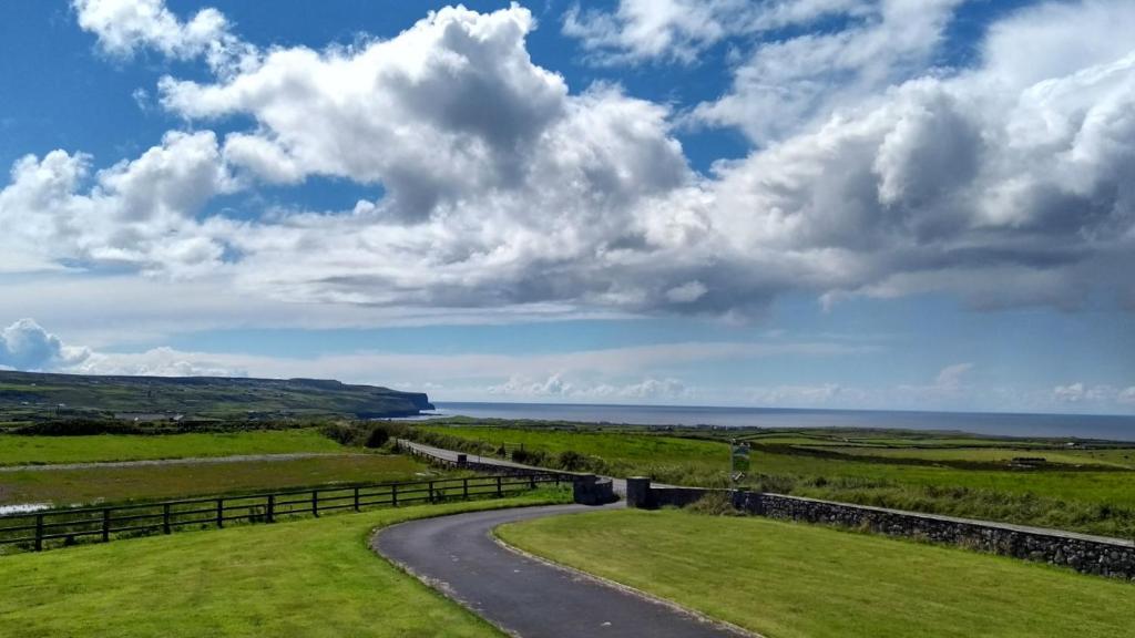 a road leading to the ocean under a cloudy sky at Ceol na dTonnta in Doolin
