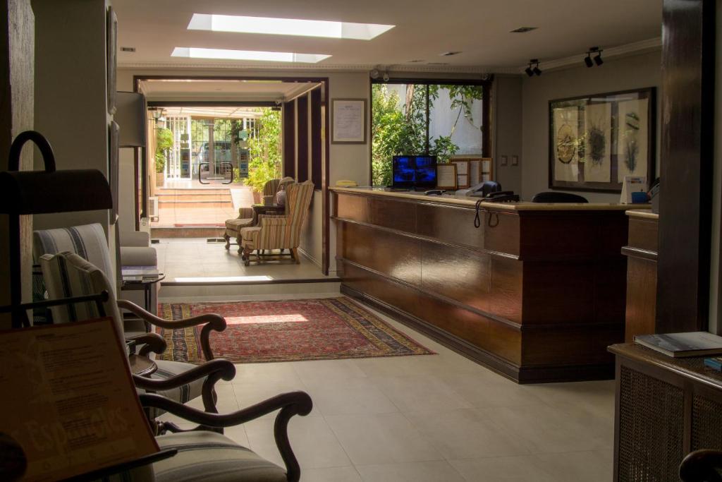 a lobby with a bar and chairs in a room at Teclados Hotel in Santiago