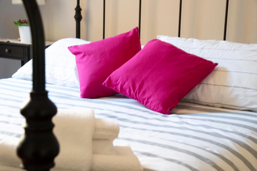 two pink pillows sitting on top of a bed at Gregorios San Pietro Guesthouse in Rome