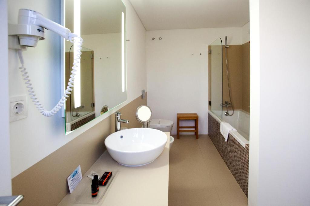 uma casa de banho branca com um lavatrio e um WC em Convento Da Serta Hotel na Sert
