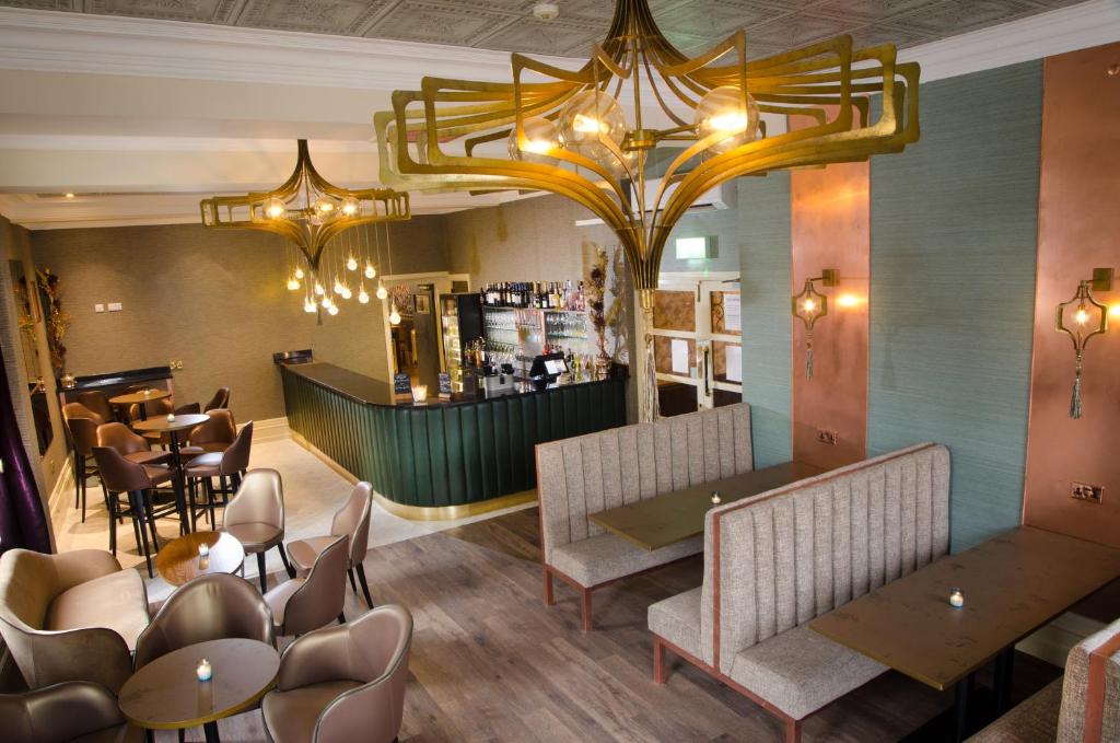 um restaurante com mesas e cadeiras e um bar em The Royal Station Hotel em Carnforth