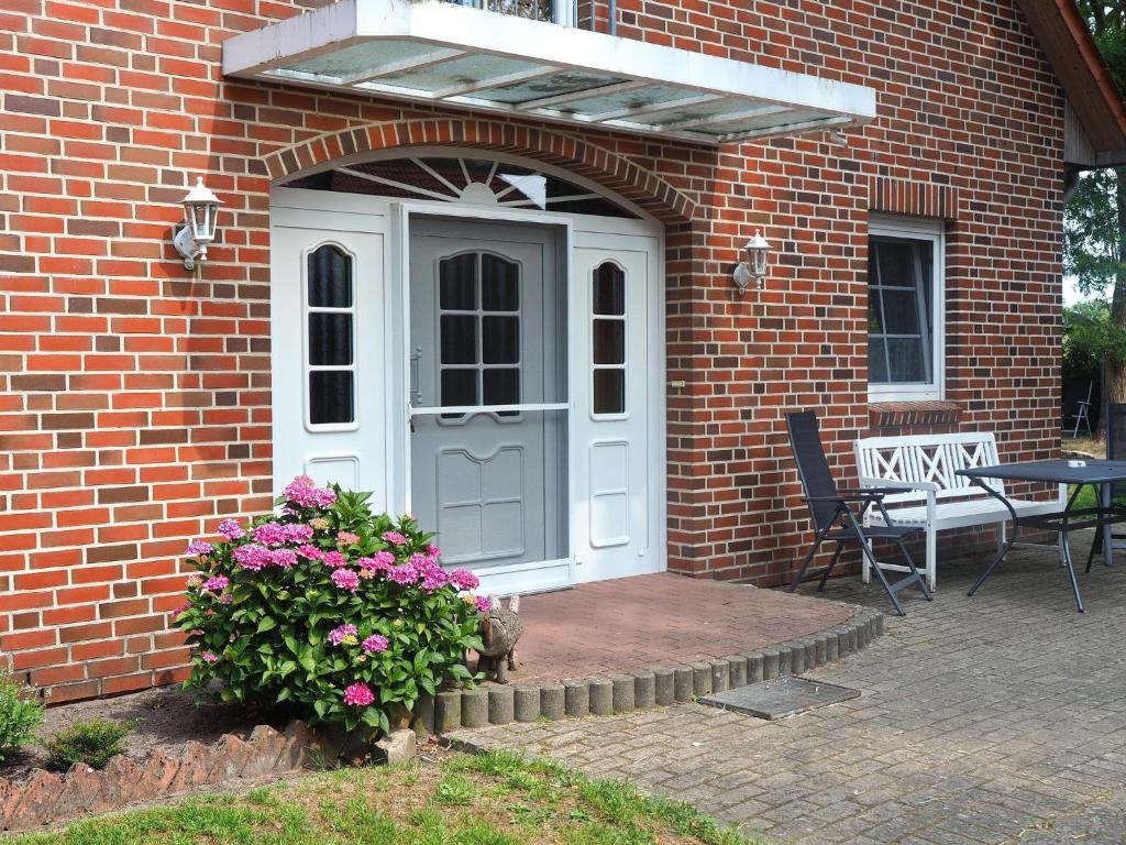a brick house with a white door and a bench at Ferienhof Scholbe in Schneverdingen