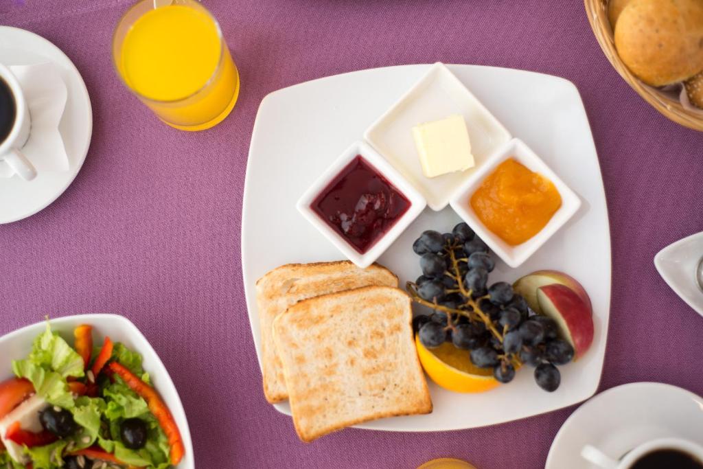 a plate of food with toast and a salad and fruit at Unirea Hotel & Spa in Iaşi