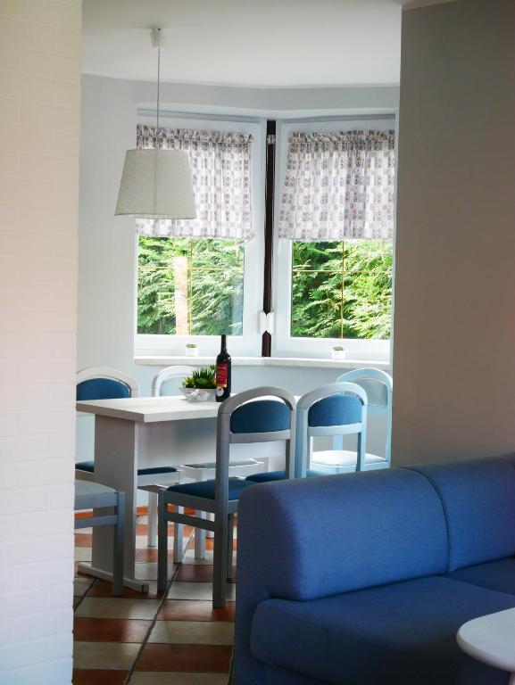 a living room with a blue couch and windows at Niewinne domki - Alentejo in Żywiec