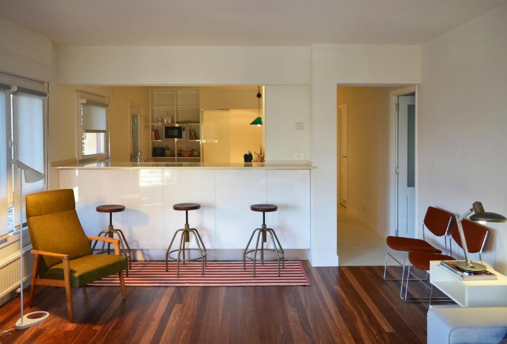 a living room with a kitchen with stools at ATERIAN. SANZ ENEA in Zarautz