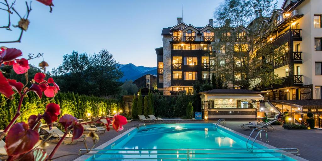 un hôtel avec une piscine en face d'un bâtiment dans l'établissement Premier Luxury Mountain Resort, à Bansko