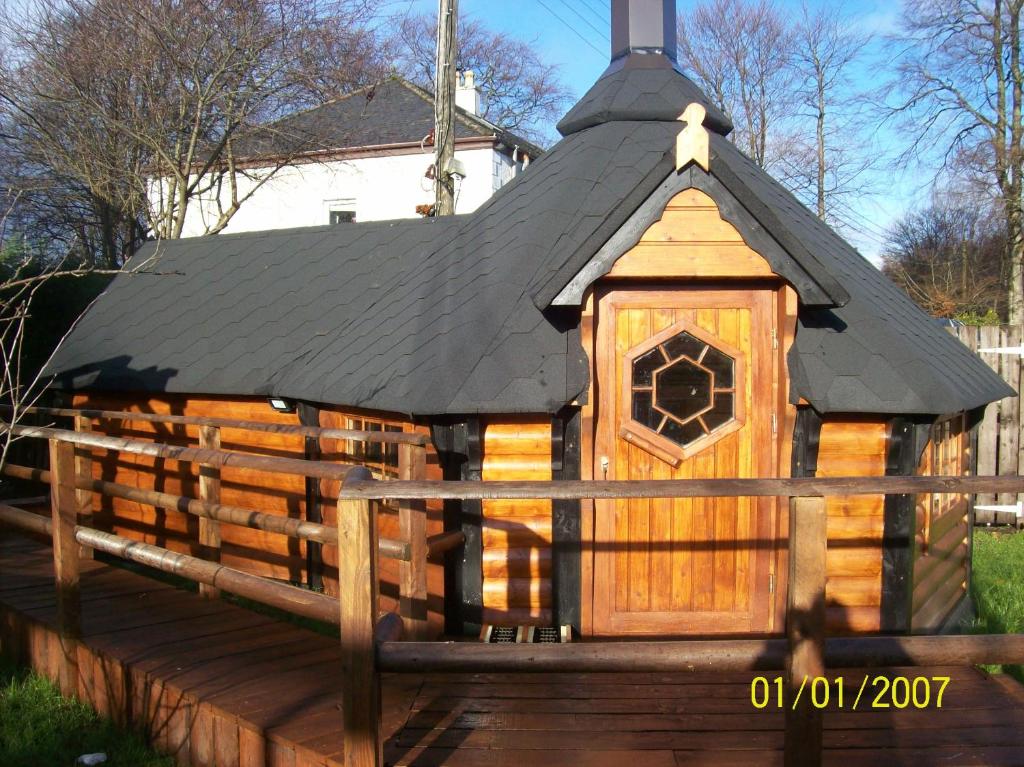 a large wooden dog house with a black roof at The Hobbit House in Fort William