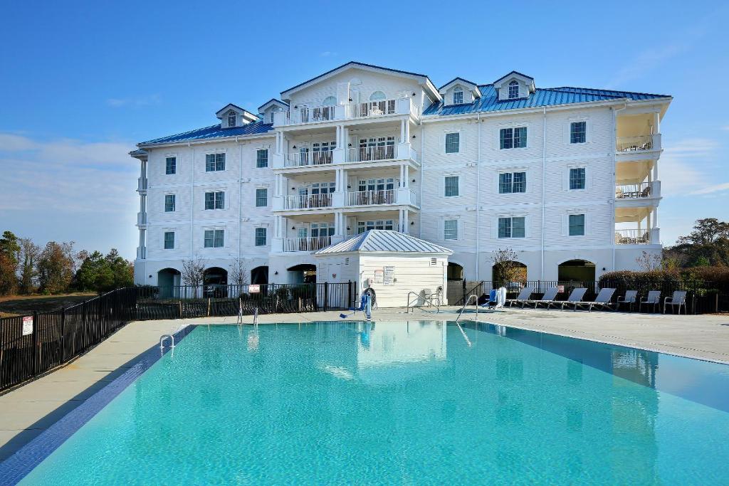 un grand bâtiment blanc avec une grande piscine dans l'établissement Waterside Resort by Capital Vacations, à Edenton