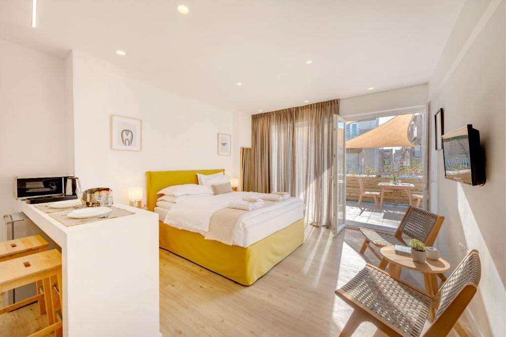 une chambre d'hôtel avec un lit, une table et des chaises dans l'établissement Maryflower Premium Apartments Piraeus, au Pirée