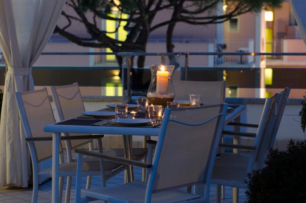 einen blauen Tisch mit Stühlen und eine Kerze drauf in der Unterkunft Dante 124 | Appartamenti a Riccione in Riccione